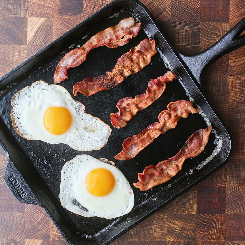 Bacon and Sunny Side eggs freshly prepared on griddle.