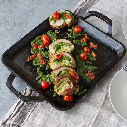 Freshly prepared chicken with pesto and tomato's, made and served on griddle.