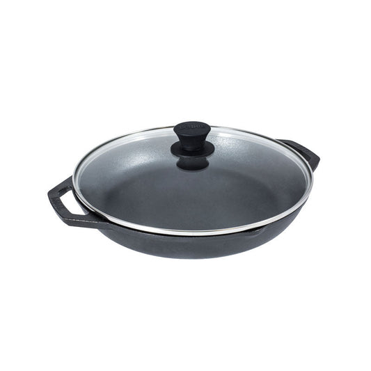 A dual handle cast iron pan with 2 pour spouts topped with a glass lid.