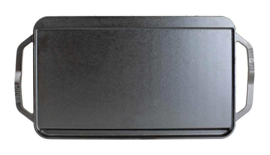 Top view featuring the griddle side showing slot for grease to fall and a constructed handle shape for easy use on each side.