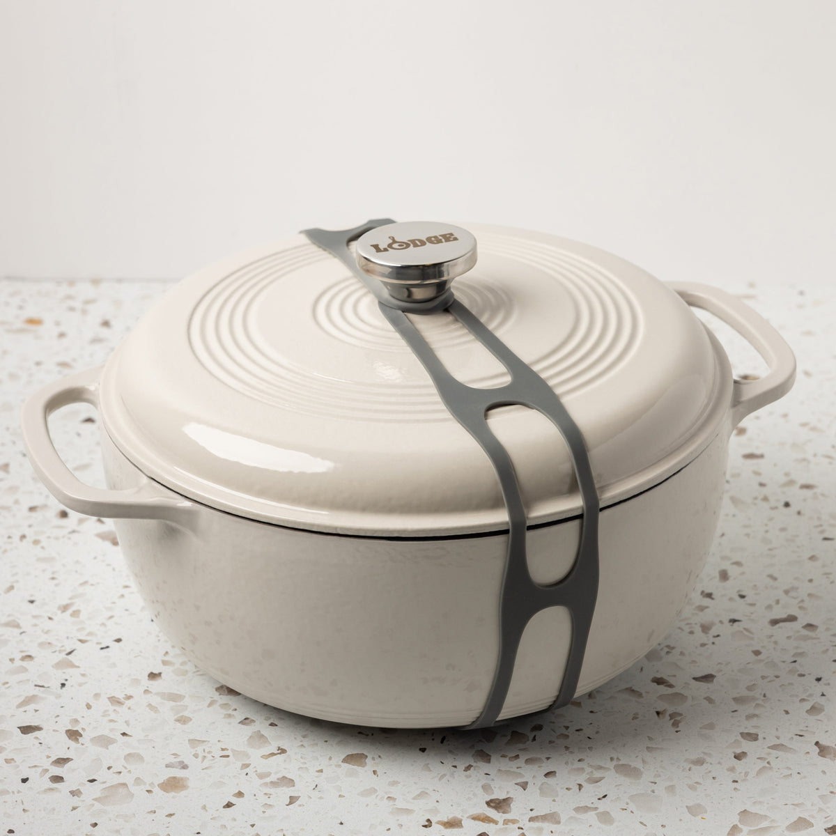 Grey lid latch being used on enamel dutch oven.