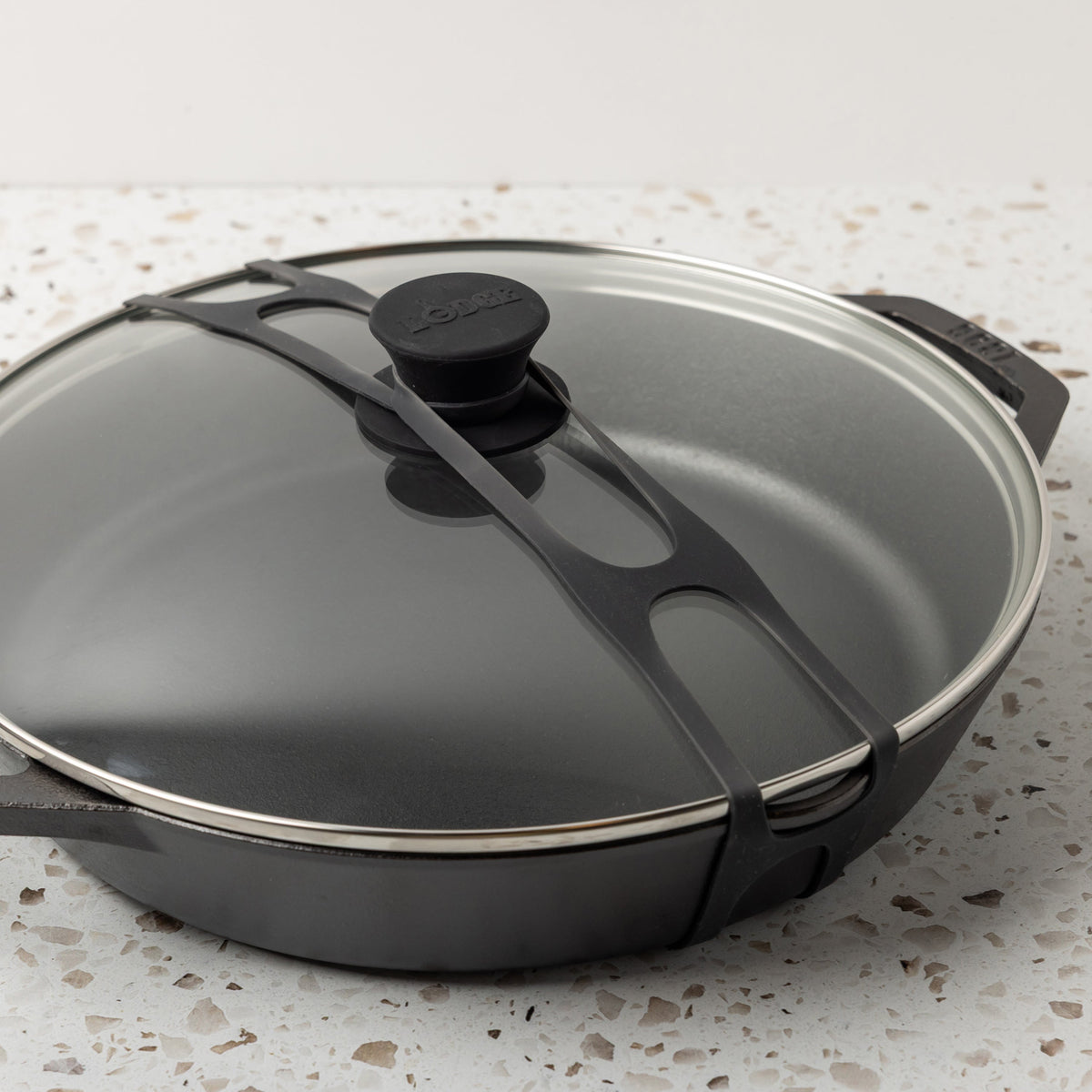 Close up shot of black lid latch being used on our everyday pan and glass lid.
