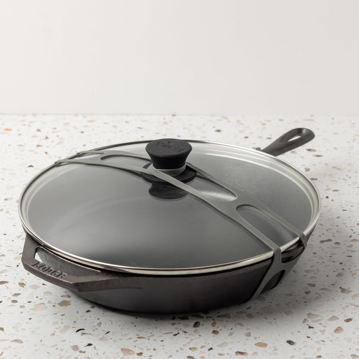 Gray lid latch being use with a glass lid and classic skillet.