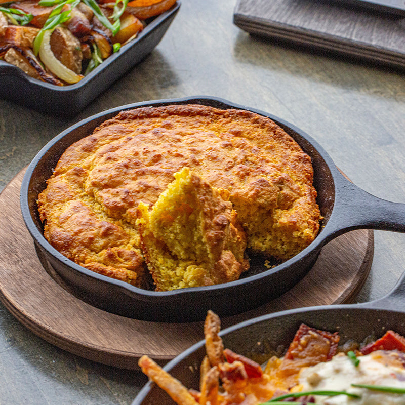 Partially eaten cornbread, served in skillet with underliner.