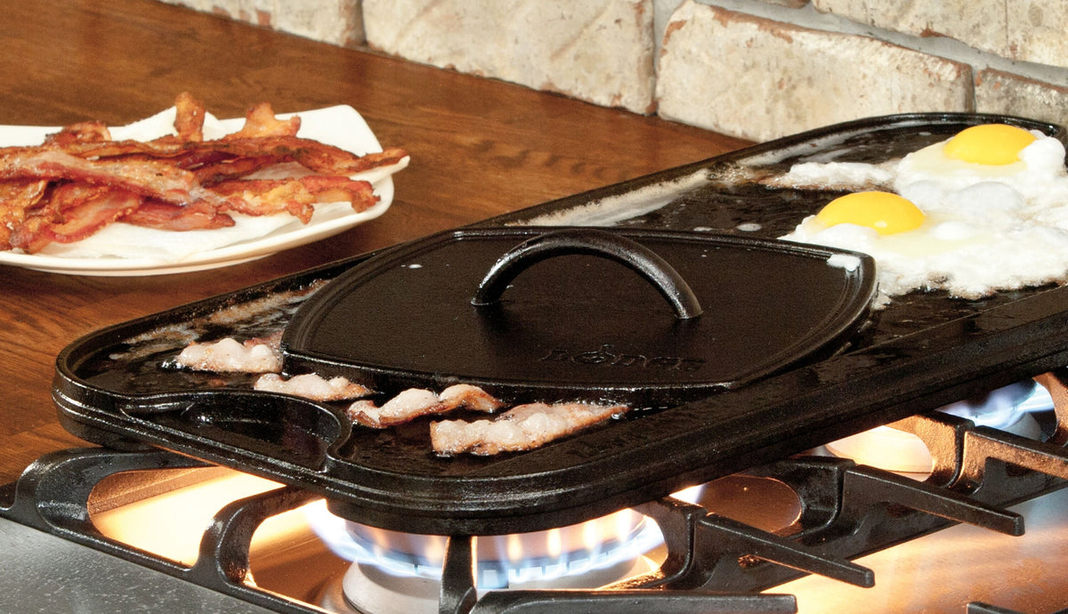 Grill press being used to press bacon while cooking on griddle.