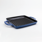 Enameled, square grill pan with a blue exterior and a black cooking surface.