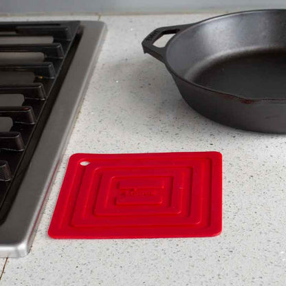 Potholder laying flat on kitchen counter next to stove.