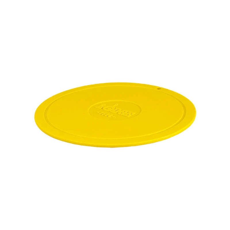 Yellow circular trivet with Lodge branding in center.
