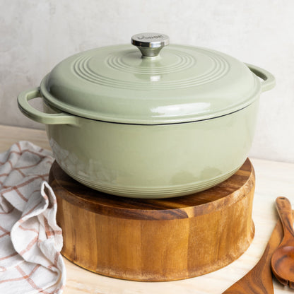 Enameled cast iron cookware on a wooden stand with a white background