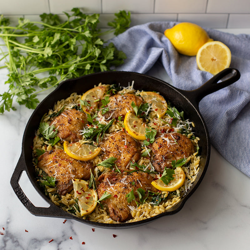 Lemon chicken orzo, served in cast iron skillet.