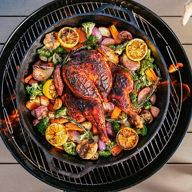 Chicken being cooked with veggies in pan.