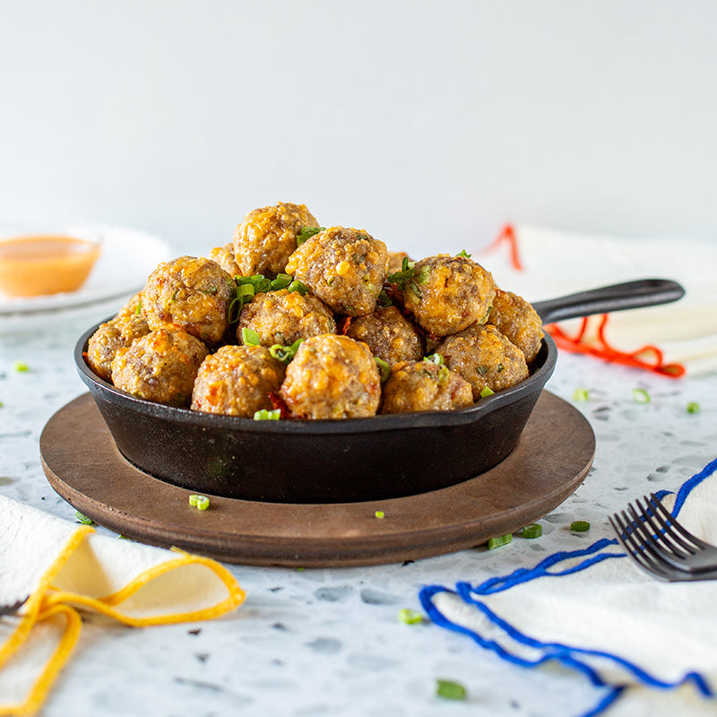 Fresh sausage balls served in skillet with underliner.