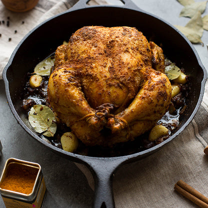 Freshly made seasoned chicken in cast iron skillet.
