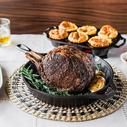 Freshly made tomahawk steak with rosemary in cast iron skillet.