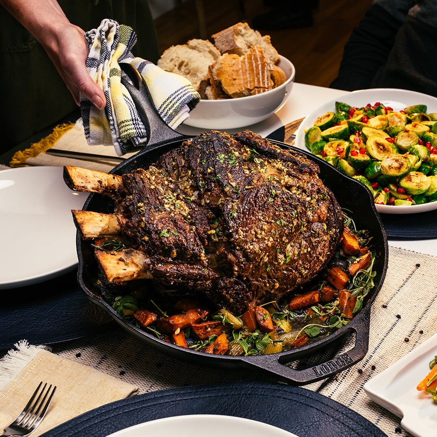 Our seared standing rib roast recipe, prepared and served in skillet on dining table.