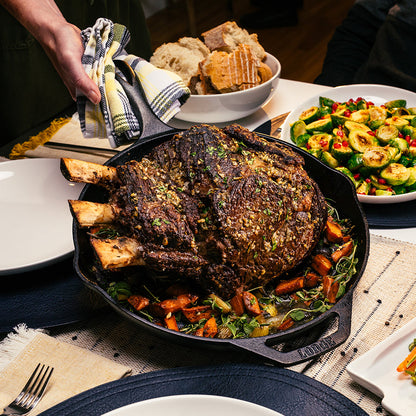 Our seared standing rib roast recipe, prepared and served in skillet on dining table.