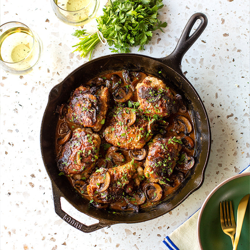 Freshly prepared meal served with a parsley garnish and white wine.