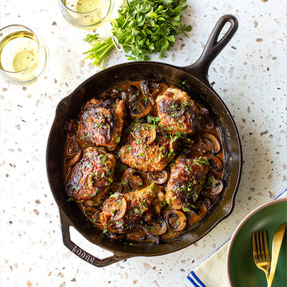Freshly prepared meal served with a parsley garnish and white wine.